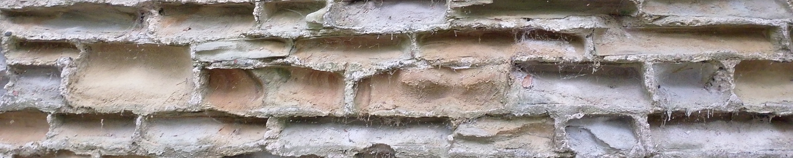 A weathered drystone wall with patches of moss, photographed mid-distance.